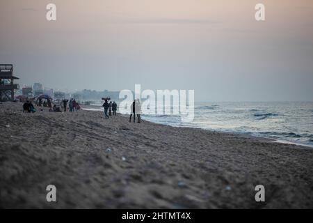 Gaza, Palästina. 01. März 2022. Palästinenser genießen am Ufer des Mittelmeers während des Sonnenuntergangs in Gaza City. (Foto von Yousef Masoud/SOPA Images/Sipa USA) Quelle: SIPA USA/Alamy Live News Stockfoto