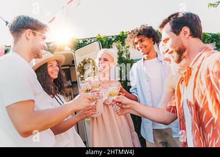 Freunde machen ein Picknick und stoßen mit Wein an Stockfoto