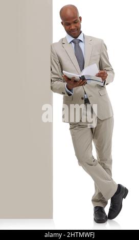 Die neuesten Geschäftszahlen. Ein afroamerikanischer Geschäftsmann, der durch ein Buch blättet - isoliert. Stockfoto