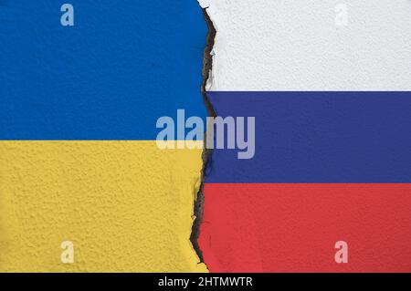 Nahaufnahme Ukraine und Russland bemalten Fahnen an einer Wand mit einem Riss.Konzept der Beziehungen zwischen Russland und der Ukraine. Stockfoto