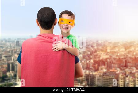 Glücklicher, liebevoller Vater. Papa und sein Sohn spielen draußen. Vater und Junge verkleidet als Superhelden. Vatertag Konzept. Stockfoto