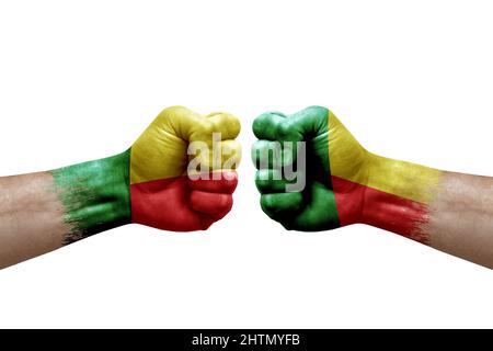 Zwei Hände schlagen sich gegenseitig auf weißem Hintergrund zu. Länderflaggen bemalten Fäuste, Konfliktkrisenkonzept zwischen benin und benin Stockfoto