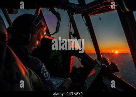 US Air Force Captain Shannon Hunter, 37. Airlift Squadron Section Chief, hilft Pilot einer C-130J Super Hercules zugeordnet Ramstein Air Base, Deutschland über Großbritannien, 27. Februar 2022. Ramstein ab ist zusammen mit anderen USAF-Einrichtungen in ganz Europa in der Lage, eine Vielzahl von NATO-Missionen und Notfalleinsätzen in Osteuropa zu unterstützen. (USA Foto der Luftwaffe von Staff Sgt. Jacob Wongwai) Stockfoto
