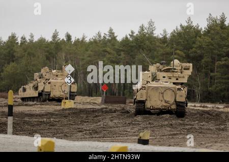 US Army m2 Bradley Infanterie Kampffahrzeuge, die der 1. Squadron, 4. Cavalry Regiment, 1. Armored Brigade Combat Team, 1. Infantry Division, zugeordnet sind, warten auf die Schusslinie in Trzebien, Polen, 22. Februar 2022. Der Cav aus dem Jahr 1-4 führte den Schießtisch von Table V durch, der die Panzerbesatzung darin schult, stationäre und bewegliche Ziele, die in taktischen Arrays platziert sind, aus einem stationären und beweglichen Panzer mit Panzerbewehrungswaffen sowohl bei Tag als auch bei Nacht zu erreichen. (USA Foto der Armee-Nationalgarde von SPC. Hassani Ribera) Stockfoto