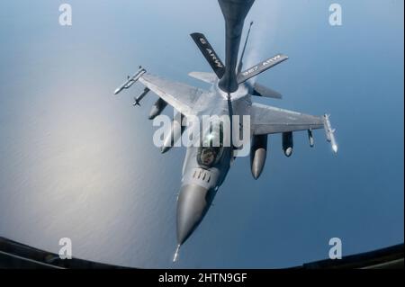 Eine F-16 Kampffalke der US-Luftwaffe, die dem 332d Air Expeditionary Wing zugewiesen wurde, verbindet sich mit einem US Air Force KC-135 Stratotanker, der der 28. Expeditionary Air Betanking Squadron zugewiesen wurde, um Lufttanken über dem Arabischen Golf durchzuführen, 26. Februar 2022. Die 28. EARS, die bei der US Air Forces Central eingesetzt wurden, betanken mit sechs US-Kampfflugzeugen aus der Luft, um eine Übung mit einem Partnerland zu unterstützen. (USA Foto der Luftwaffe von Staff Sgt. Jerreht Harris) Stockfoto