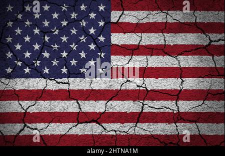 US-amerikanische Flagge auf einer rissigen und grungen Betonwand gemalt. Konzept eines Landes in Krise, Gefahr, zerrissen, gebrochen. Stockfoto