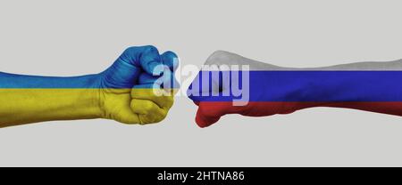 Russische gegen ukrainische Flagge Nationalmannschaft auf Faust gemalt. Konzept der Politik, wirtschaftliche Konflikte. Stockfoto