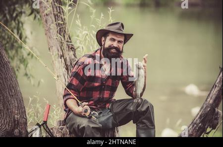Die Bachforelle wird im Fischernetz gefangen. Stahlkopf-Regenbogenforelle. Bass Fishing Splash. Forellen am Haken angeln. Fangen eines großen Fisches mit einem Angelstock. Stockfoto