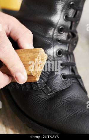 Spieß glänzen. Kurzer Nahaufnahme eines Soldaten, der seine Stiefel poliert. Stockfoto