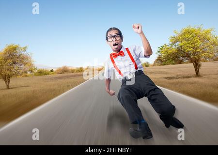 Asiatischer Nerd mit hässlichem Gesicht auf der Straße mit blauem Himmel Hintergrund Stockfoto