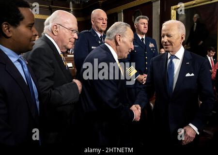 Washington, Usa. 01. März 2022. US-Präsident Joe Biden schüttelt die Hände mit Chuck Schumer (D-NY), dem Mehrheitsführer des Senats, nachdem er am 1. März 2022 die Rede zur Lage der Union auf einer gemeinsamen Kongresssitzung im US-Kapitol in Washington, DC, überreicht hatte. Poolfoto von Saul Loeb/UPI Credit: UPI/Alamy Live News Stockfoto