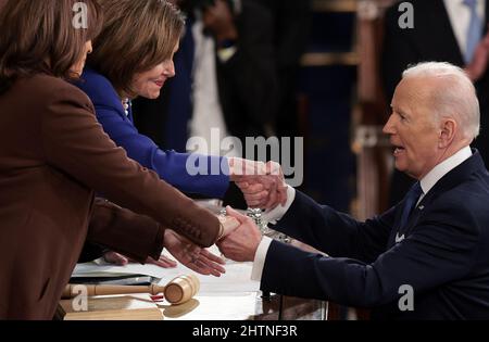 Washington, Usa. 01. März 2022. Präsident Joe Biden hält die Hände mit Vizepräsidentin Kamala Harris (L) und der Sprecherin des Repräsentantenhauses Nancy Pelosi (D-CA), nachdem sie am Dienstag, dem 1. März 2022, die Rede zur Lage der Union auf einer gemeinsamen Kongresssitzung im US-Kapitol in Washington, DC, gehalten hat. Poolfoto von Win McNamee/UPI Credit: UPI/Alamy Live News Stockfoto