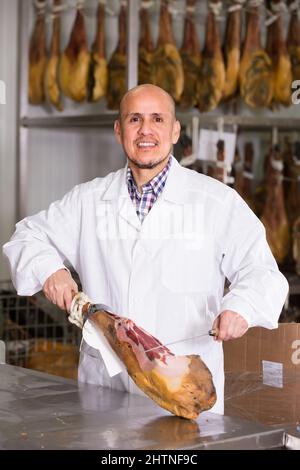 Reifer Metzger, der im Laden den Stau aufschneiden kann. Stockfoto