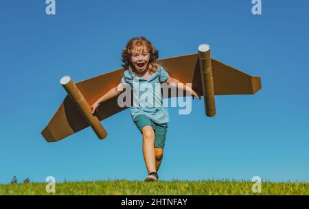 Aufgeregt Kind mit Jet Pack Superhelden. Kinderpilot läuft vor dem Hintergrund des Sommerhimmels. Erfolg, Leader und Sieger Konzept. Fantasie, Freiheit für Kinder. Stockfoto