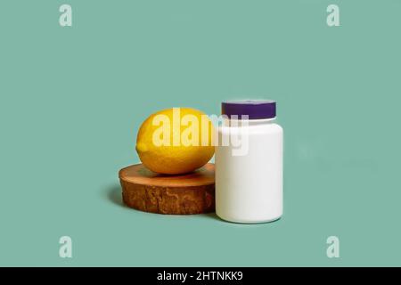 Modell. Ein weißes Plastikglas mit violettem Deckel und Zitrone auf einem Holzständer Stockfoto