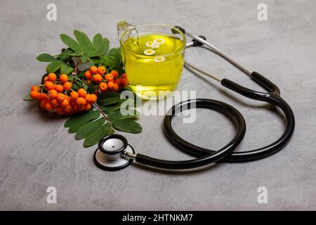 Grüner Tee mit Kräutern auf rustikalem Hintergrund. Kräutermedizin. Stockfoto
