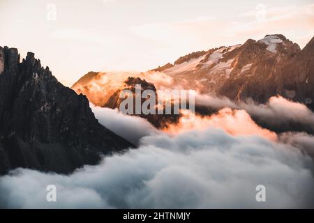 Wunderschöne Aufnahme von Nebel und Wolken, die die Dolomiten bei Sonnenuntergang bedecken Stockfoto