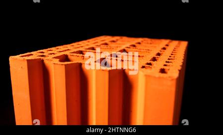 Abstrakte Animation der orangefarbenen 3d-Ziegeloberfläche auf dem schwarzen Hintergrund. Bau- und Materialkonzept Stockfoto