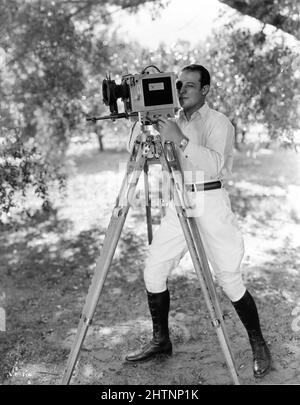 RUDOLPH VALENTINO am Drehort posiert offen mit Debie Movie Camera während der Dreharbeiten DES SOHNES DER SHEIK 1926 Regisseur GEORGE FITZMAURICE nach dem Roman von Edith Maude Hull Feature Productions / United Artists Stockfoto