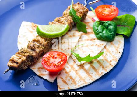 Kräuterspieß mit Pita-Brot, Tomaten und Limette Stockfoto