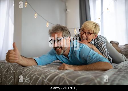Aufgeregt reifes Paar mit Spaß zu Hause. Frau und Mann verbringen Wochenende zusammen, lustige Aktivität Stockfoto