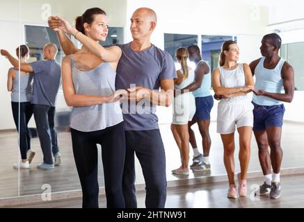 Junge lächelnde Menschen üben leidenschaftlich Samba im Tanz Klasse Stockfoto