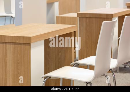 Weiße Stühle und Tisch im Innenbereich. Moderne, komfortable Holzmöbel Stockfoto