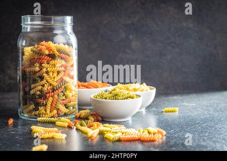 Drei Farben Fusilli Pasta. Bunte italienische rohe Pasta im Glas. Stockfoto