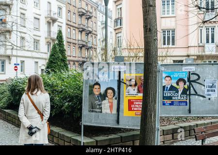 Straßburg, Frankreich - 21. März 2015: Neugierige Französin, die vor den Kommunalwahlen in der Nähe der politischen Plakate in der französischen Nachbarschaft Werbung macht Stockfoto