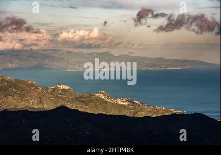 Ein Fernblick über die Stadt Taormina, Sizilien, Italien und über die Straße von Messina nach Kalabrien auf dem italienischen Festland Stockfoto