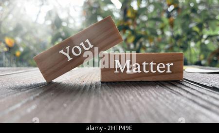 Sie spielen eine Rolle für Text auf Holzblöcken mit heller Sonne und Parkhintergrund. Stockfoto