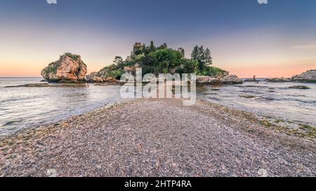 Isola Bella Nature Reserve - eine kleine paradiesische Insel an der Küste von Taormina, Sizilien. Farbenfroher Sonnenaufgang über der wunderschönen Bucht Stockfoto