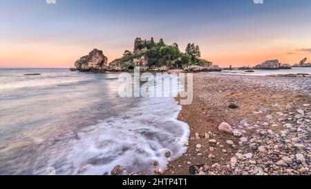 Isola Bella Nature Reserve - eine kleine paradiesische Insel an der Küste von Taormina, Sizilien. Farbenfroher Sonnenaufgang über der wunderschönen Bucht Stockfoto