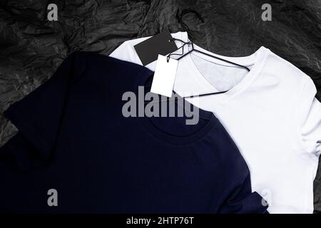 Modell eines blau-weißen Baumwoll-T-Shirts auf schwarzem Hintergrund. Nahaufnahme mit Tag Stockfoto