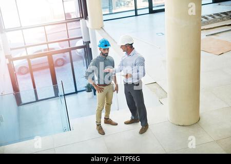 Inspektion der Baustelle. In der Lobby des Büros sprechen zwei Geschäftsleute aus dem Hochwinkel. Stockfoto