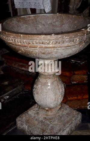 Taufschrift in der christlichen Kirche. Taufe aus Stein in der historischen Kirche. Stockfoto