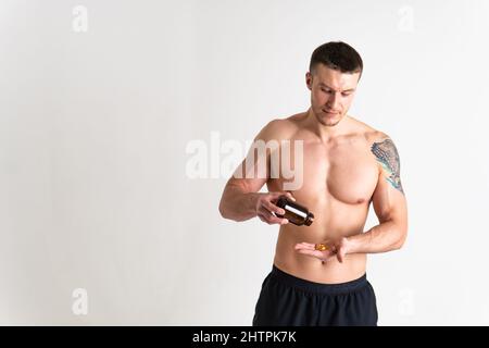 Fischöl wird von einem Mann in den Händen von Fläschchen und einer Glasflasche Pille Gesundheit Vitamin, Ernährung Apotheke pharmazeutische Gesundheitsversorgung, Kabeljau gegessen. Lächeln Stockfoto