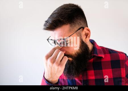 Porträt eines Mannes, der müde ist und Kopfschmerzen hat. Stockfoto