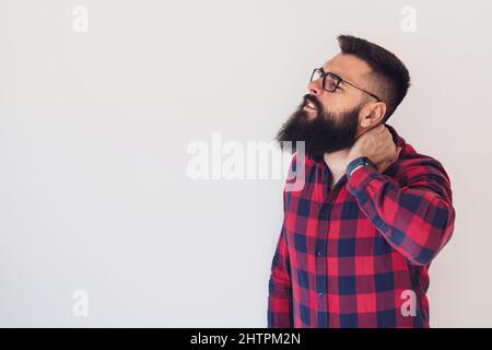 Porträt eines jungen Mannes, der Schmerzen im Nacken hat. Kopieren Sie Platz auf dem Bild für Ihren Text oder Ihre Anzeige. Stockfoto