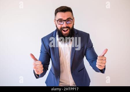 Porträt eines glücklichen Geschäftsmannes, der lächelt und den Daumen nach oben zeigt. Kopieren Sie Platz auf dem Bild für Ihren Text oder Ihre Anzeige. Stockfoto
