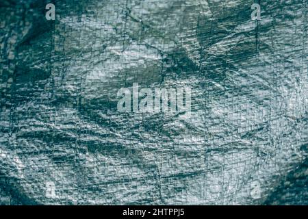 Abstrakt realen Stoff Oberfläche Hintergrund. Aluminium Platinum Silver Folie Tarpaulin Effekt mit rauer Textur Grapfkante. Futurism 80s Retro-Stil neu Stockfoto