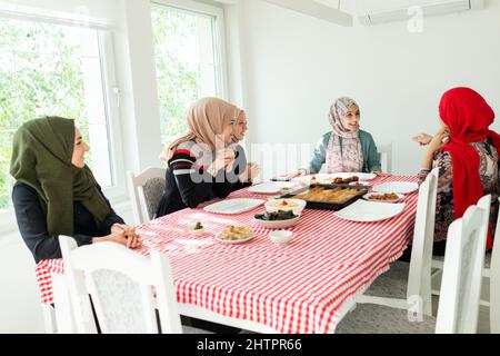 Muslimische Familie und Freunde treffen sich zu Hause zum Abendessen. Hochwertige Fotos Stockfoto