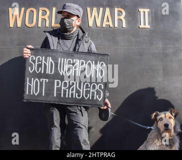 London, Großbritannien. 26.. Februar 2022. Ein Protestler hält neben dem Denkmal für die Frauen des Zweiten Weltkriegs ein Plakat mit dem Titel „Waffen senden, keine Gebete“ Tausende von Menschen versammelten sich in Whitehall, um gegen die russische Invasion in der Ukraine zu protestieren und riefen die britische Regierung und die NATO dazu auf, der Ukraine zu helfen. Stockfoto