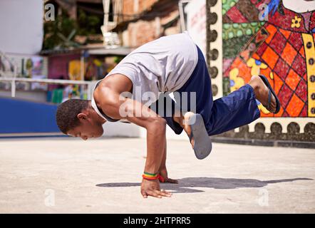 Capoeira-Kultur. Low-Angle-Aufnahme eines jungen Breakdancers in einer urbanen Umgebung. Stockfoto