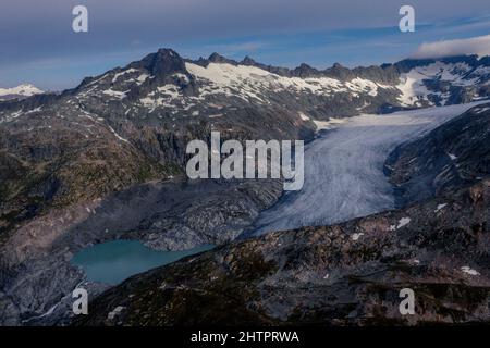 Luftaufnahme des Rhonegletschers im Sommer 2021. Am Grund des Gletschers befindet sich der See, der durch das kontinuierliche Schmelzen des Eises durch den Klimawandel gebildet wird. Hochwertige Fotos. Stockfoto