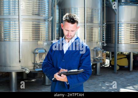 Porträt eines jungen Arbeiters in der Weinfabrik Stockfoto