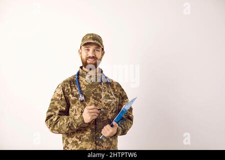 Porträt eines glücklichen Militärarztes in Tarnuniform mit Klemmbrett und Lächeln Stockfoto