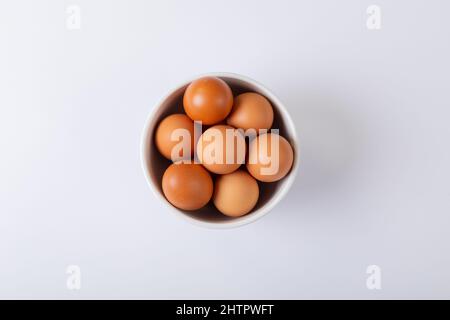 Direkt über dem Schuss brauner Eier in einer Schüssel auf dem Tisch Stockfoto
