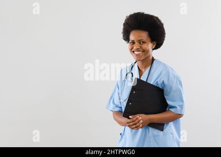 Porträt eines glücklichen afroamerikanischen Arzt für mittlere Erwachsene mit Zwischenablage auf weißem Hintergrund, Kopierraum Stockfoto