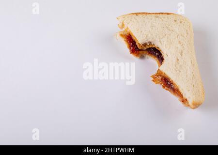 Nahaufnahme eines fehlenden Bisses auf Erdnussbutter und Gelee-Sandwich auf weißem Hintergrund mit Kopierfläche Stockfoto